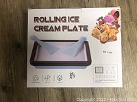 Box of rolling ice cream plate with two spatulas illustrated on the packaging