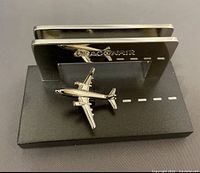 Front view of Dragonair business card holder showing airplane model on runway-style base with card slot and Dragonair logo.
