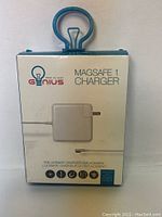 Front side of the retail packaging for the That is Genius Magsafe 1 Charger. The image shows the brand logo, product name, charger image, and some text.