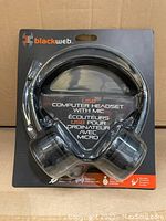 Front view of Blackweb USB computer headset in original packaging showing headset and details about microphone and USB connection.