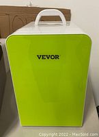 Front view of the Vevor mini fridge with light green front panel showing brand name and top handle.