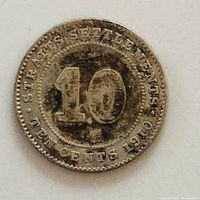 Reverse side of the 1910 Straits Settlements 10 cent coin showing denomination and date with tarnish.