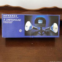 Photo of the packaged infrared passive sensor security light in its blue box showing dual bulbs and sensor unit.