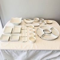 Entire set of white ceramic kitchenware including sushi plates, sectional platter, ramekins, and smaller dishes