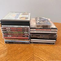 Photo of stacked CDs and cassette tape showing titles and artists included in the lot