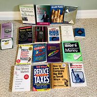 Full view of 18 paperback books laid out on carpet in 3 rows. Titles visible covering success, money management, finance, and personality development.