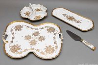 All four porcelain serving pieces arranged on gray background showing overall set.