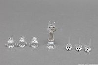 Front view showing all seven figurines lined up on grey background.