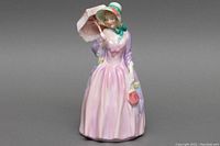 Front view of the 7.5-inch Royal Doulton porcelain figurine Miss Demure with parasol and handbag.