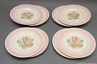 Top view of 8 plates arranged in pairs showing floral design and pink gradient rim.