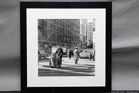 Framed black and white photograph showing urban street scene with pedestrians and cars in Montreal circa 1955
