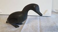 Front side view of the dark soapstone duck carving showing repaired neck and smooth body