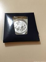 Front view of the 2011 Canadian 20 Dollar Fine Silver Maple Leaf coin in a navy blue package with a window showing the coin's face.