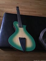 Front view of headless electric guitar on bench