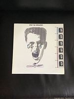 Front of album cover showing stylized man's face and photos down the side