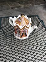 Side view of the octagonal Sadler teapot showing portraits of King Henry VIII and his wives, along with detailed gold accents on the edges and lid knob.
