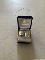Pair of large baroque pearl clip-on earrings in a blue velvet box with the words 'Sterling De Luxe Kingston' inside the lid.
