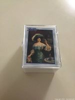 Front view of the clear plastic case with the top card showing a vintage illustration of a woman in period dress.