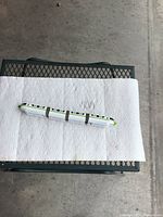 Top-down view of the 4-piece Disney metal monorail train set arranged on white paper towels on a metal grid surface, showing overall length and details of the first side.