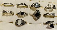 Front view of 10 ladies rings displayed on a white background showing different designs, stones, and bands