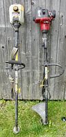 Two gas trimmers hanging on a wooden fence, showing overall condition and design differences between Ryobi and Homelite units.