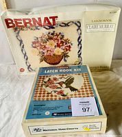 Two new latch hook kits in original packaging. One Bernat Nantucket Basket 30" x 37" floral design and one Natura hummingbird latch hook kit.