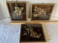 Closeup of the three embossed desert-themed glass framed 3D art pieces showing details of human figures and animals.