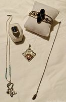 Photo showing entire vintage jewelry set including the ring with lapis lazuli, bracelet with blue crystals, jasper pendant, charm necklace, and chain necklace.