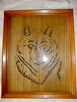 Front view of the framed carved and sketched wolf wood art