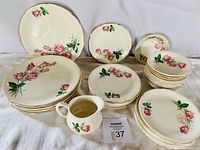 Display of full 39-piece set laid out on cloth showing pattern and components
