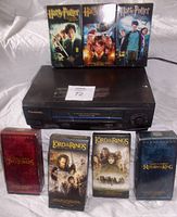 Panasonic 4-head Hi-Fi stereo VHS player with 7 VHS tapes placed on and around it. Tapes include 4 Lord of the Rings movies and 3 Harry Potter movies with color illustrated covers.