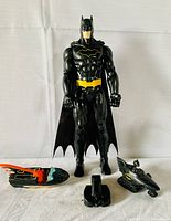 Four vintage Batman toys including a 12-inch Batman figure and three Bat-themed vehicles (car, boat, Sea Doo) displayed against a white background.