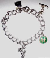 Full view of the Norway sterling silver 925 charm bracelet with four distinct charms: bicycle, grand piano, skiing scoop, and green enamel couple walking charm.