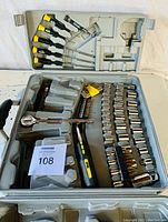 Top view of the open hard plastic carrying case showing the ratchet wrench, screwdriver, precision screwdrivers, sockets, and Allen keys organized in molded compartments.