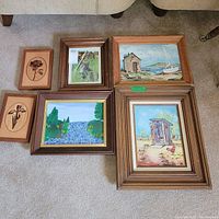 Overview photo of all six framed artworks arranged on floor showing different subjects including wood art and paint by number.