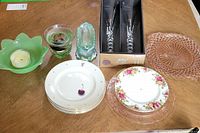 Overview of plates, candle holders, and boxed cutlery on wooden table