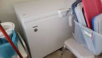 Front view of white Whirlpool chest freezer among household items