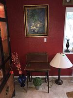 Photo showing three nesting folding snack tables, a floor lamp with white shade, a faux floral arrangement in a blue vase with lights, and a green faux plant.