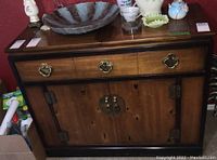 Front view of Lane wood fold-out buffet cabinet with brass hardware, dark wood, and black trim.
