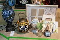 Full view of the lot showing lamp, teapot, urn, picture frames, and vase.