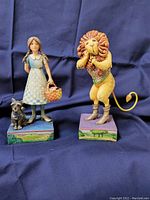 Photo of two Jim Shore figurines, one of Dorothy with Toto and one of the Cowardly Lion.