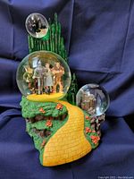 Photo of the Wizard of Oz themed music box showing the yellow brick road, character globe, and Emerald City globe