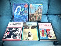 Top view of 5 hardback art history books showing cover art for Chagall, Italian Renaissance, Haring, Dali, and 20th Century Posters.