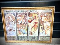 Front view of framed art featuring four panels representing the seasons with ornate gold frame