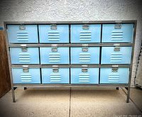 Full front view showing overall cabinet with three rows of four blue drawers in gray steel frame