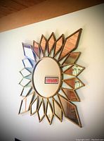 Sunburst wall mirror on white wall showing full radial design