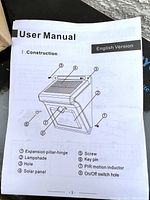 User manual showing parts of a Baxia solar motion sensor light, including solar panel, PIR motion sensor, on/off switch hole, and expansion pillar-hinge.
