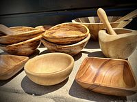 Group of wooden bowls including oval and square shapes, and olive wood pestle and mortar