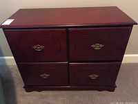 Front view of the four-drawer fiber wood file cabinet with brass handles.