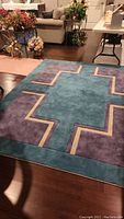 Photo of custom made teal, lilac, and cream geometric area rug.